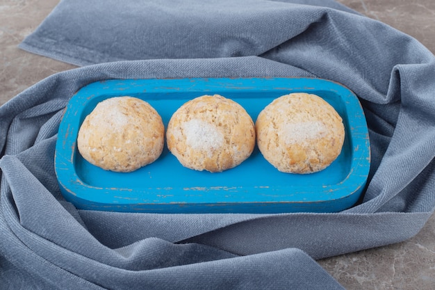 Photo gratuite biscuits friables sur un plateau bleu sur un morceau de tissu sur marbre