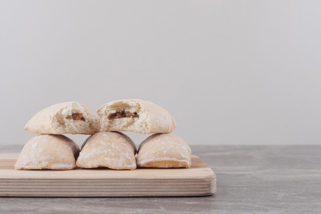 Biscuits avec garniture regroupés sur une planche sur du marbre