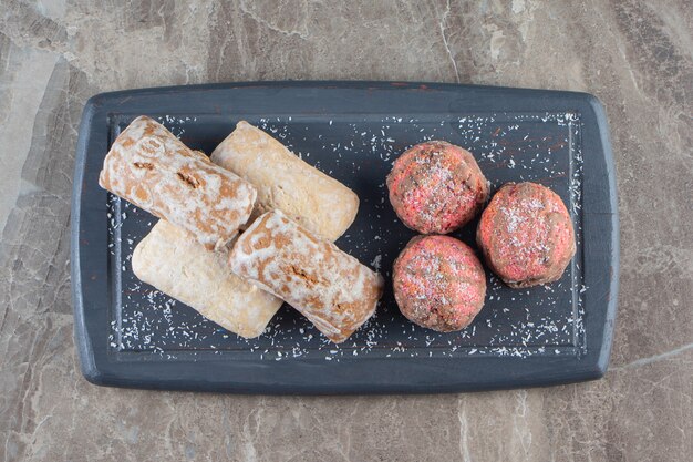 Biscuits glacés et pains d'épice sur un plateau en marbre.