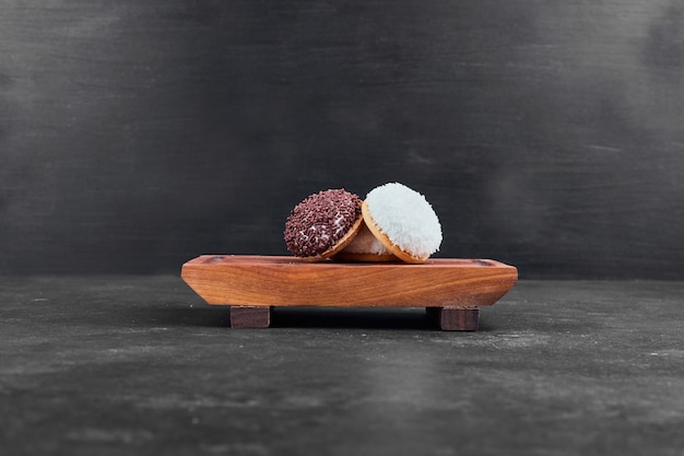 Photo gratuite biscuits à la guimauve sur un plateau en bois sur fond noir