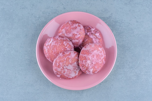 Biscuits maison roses sur plaque rose.