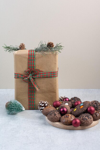 Biscuits de Noël avec boîte-cadeau, boules et pommes de pin. photo de haute qualité