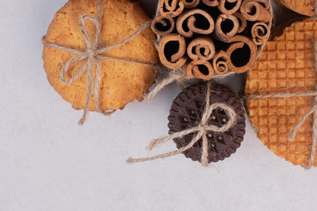 Biscuits de Noël à la cannelle en corde sur tableau blanc.