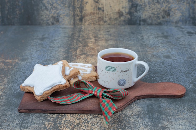 Biscuits de Noël avec tasse de thé sur planche de bois