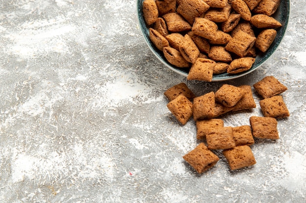 Biscuits d'oreiller sucrés à l'intérieur de la plaque sur blanc