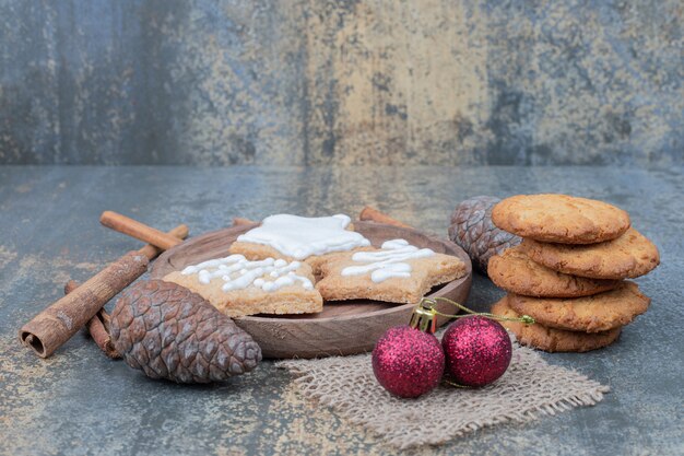 Biscuits en pain d'épice en forme d'étoile sur une assiette avec des boules de Noël. Photo de haute qualité