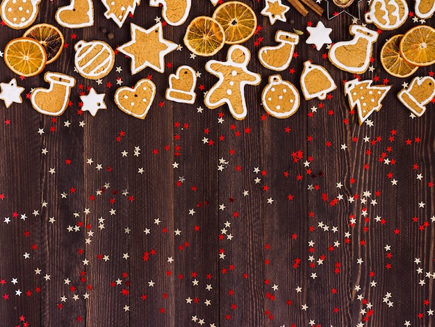 Photo gratuite biscuits de pain d'épice noël nouvel an oranges cannelle sur table en bois