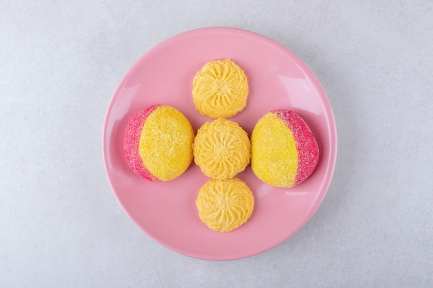 Biscuits sur une plaque rose, sur le marbre.