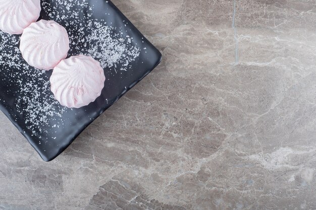 Biscuits sur un plateau noir sur une surface en marbre