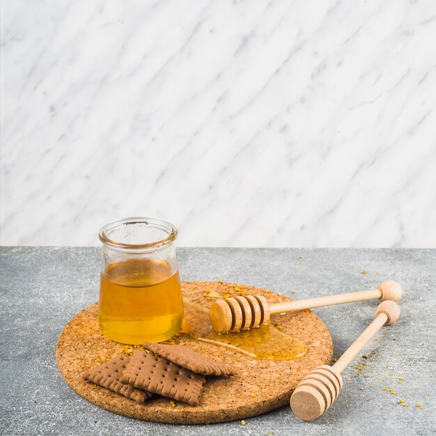 Biscuits et pot de miel avec une louche en bois sur des montagnes russes