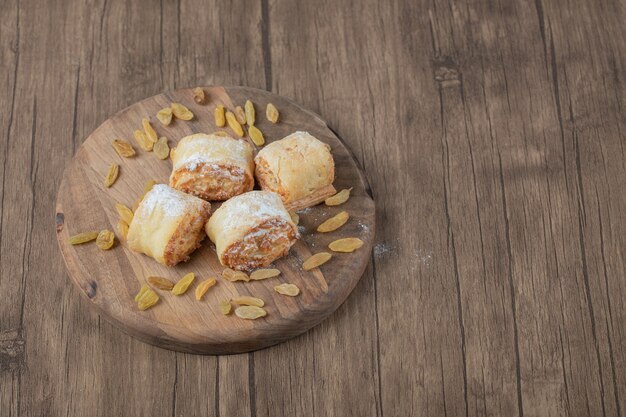 Biscuits roulés croustillants avec farce sur une planche de bois.