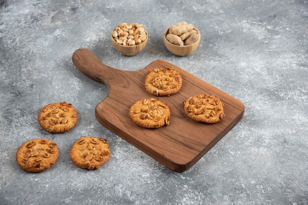 Biscuits savoureux avec des arachides biologiques et du miel sur planche de bois.