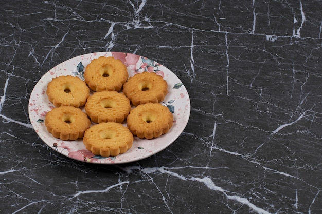 Biscuits savoureux dans l'assiette, sur la surface en marbre