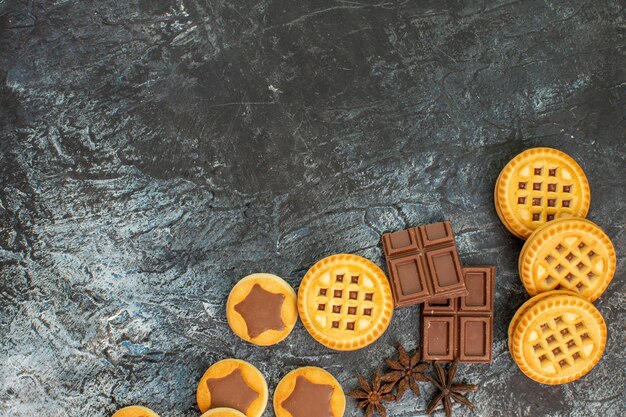 Photo gratuite biscuits sucrés avec des barres de chocolat sur le côté droit du gris