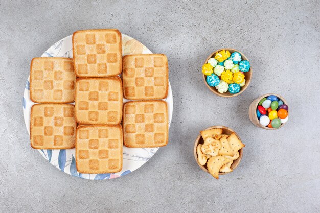 Biscuits sucrés avec des bonbons colorés sur une surface grise