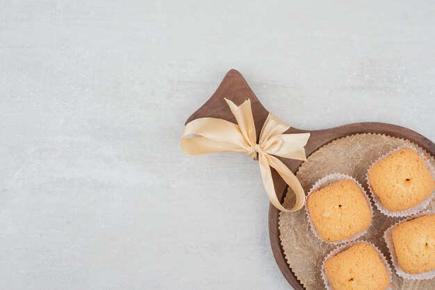 Biscuits sucrés à la crème sur une plaque en bois