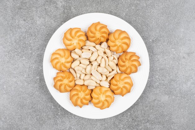 Biscuits sucrés faits maison et noix de cajou sur plaque blanche