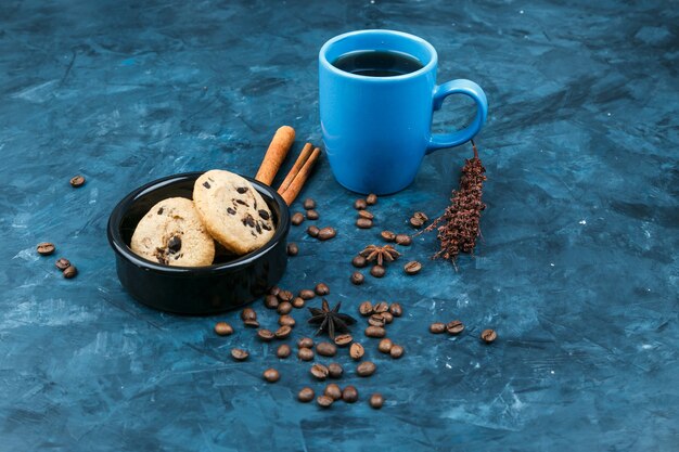 Biscuits et tasse de café sur fond bleu foncé