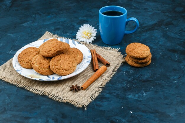 Biscuits et tasse de café sur fond bleu foncé