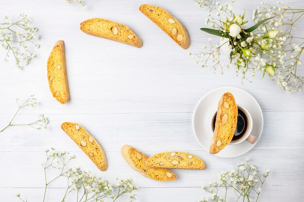 Biscuits traditionnels toscans italiens cantuccini aux amandes, une tasse de café à la lumière