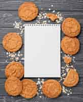 Photo gratuite biscuits vue de dessus et bloc-notes vide