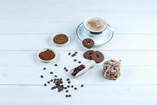 Biscuits de vue grand angle, tasse de café avec bol de café instantané, grains de café sur fond de planche de bois blanc. horizontal