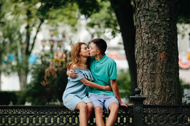 Bisous couple assis sur une clôture à l&#39;extérieur