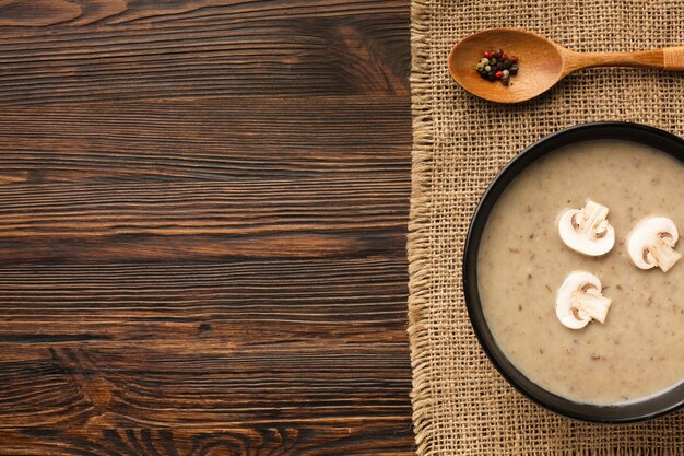 Bisque plate de champignons et cuillère avec espace de copie