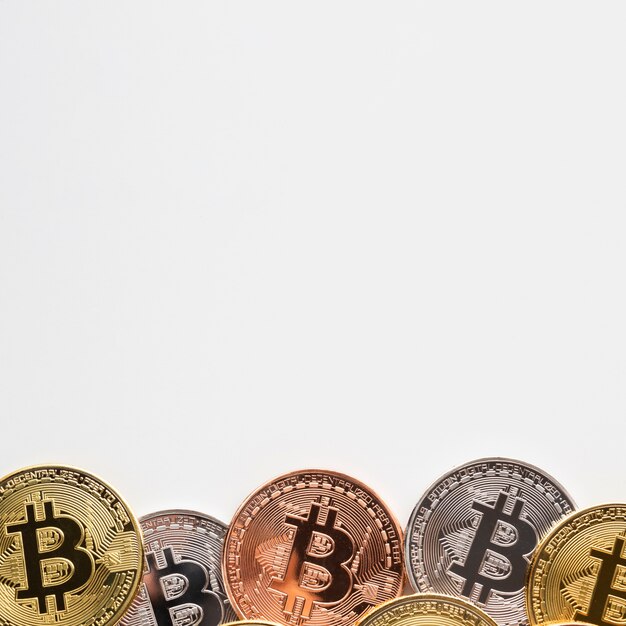 Bitcoin de différentes couleurs sur fond uni