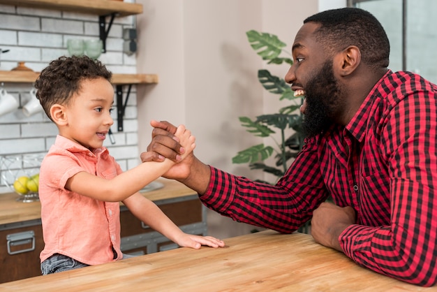 Photo gratuite black père et fils bras de fer