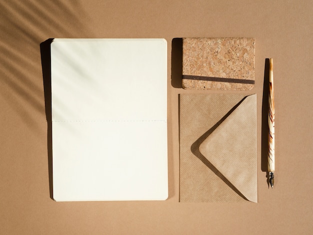 Blanc blanc avec un stylo beige sur fond beige avec une ombre de feuille de palmier