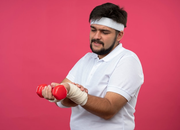 Blessé jeune homme sportif portant bandeau et bracelet avec poignet enveloppé de bandage