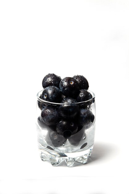 Bleuets dans une tasse en verre isolated on white