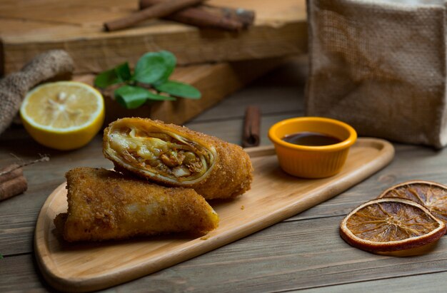 Blinchik rouleaux coupés en deux et servis avec une sauce.