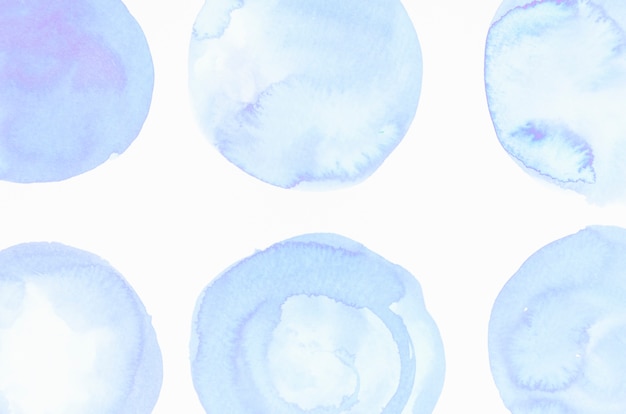 Blobs bleus de couleur liquide peints sur une toile blanche