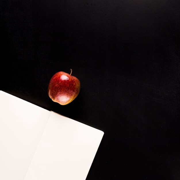 Bloc-notes avec des fruits sur un bureau noir