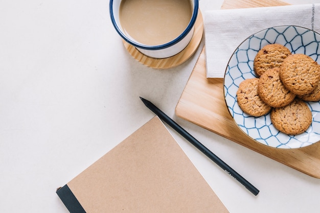 Photo gratuite bloc-notes près de biscuits et de café