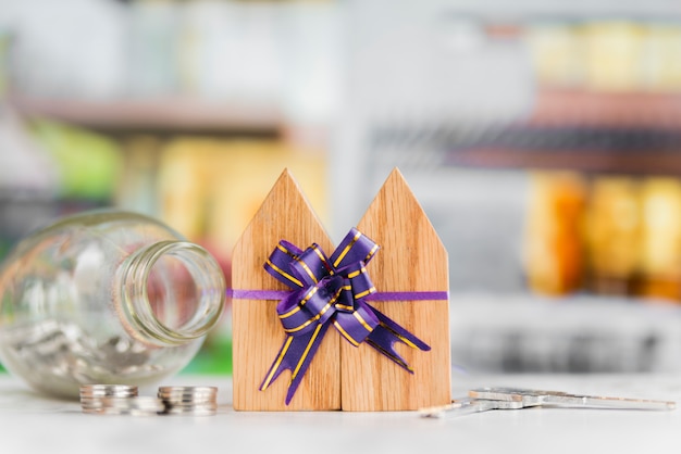 Photo gratuite blocs de maison en bois attachés avec noeud de ruban avec des pièces et des clés sur le tableau blanc