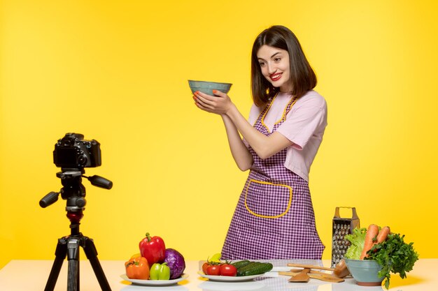 Blogueur culinaire mignon fitness cuisinier enregistrant une vidéo pour les médias sociaux tenant un bol