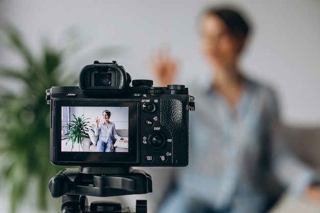 Blogueur de jeune femme enregistrant la vidéo sur l'appareil-photo