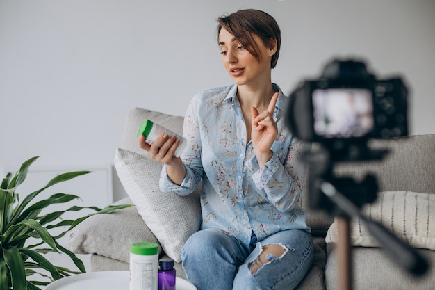 Blogueur de jeune femme enregistrant la vidéo sur l'appareil-photo