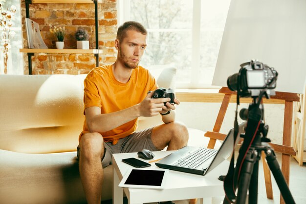 Blogueur masculin de race blanche avec examen vidéo d'enregistrement de l'appareil photo de gadgets à la maison