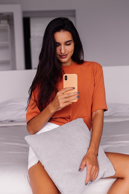 Blogueur de mode élégante jeune femme de race blanche à la maison prenant selfie photo