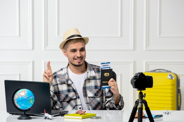 Blogueur de voyage au chapeau de paille jeune beau mec enregistrant un vlog de voyage sur caméra rêvant d'un voyage