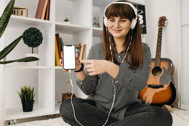 Blogueuse en streaming avec smartphone et casque à la maison