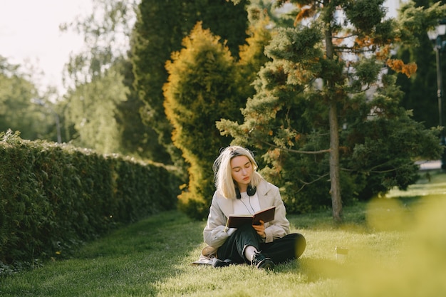 Blonde assise sur l'herbe avec un casque