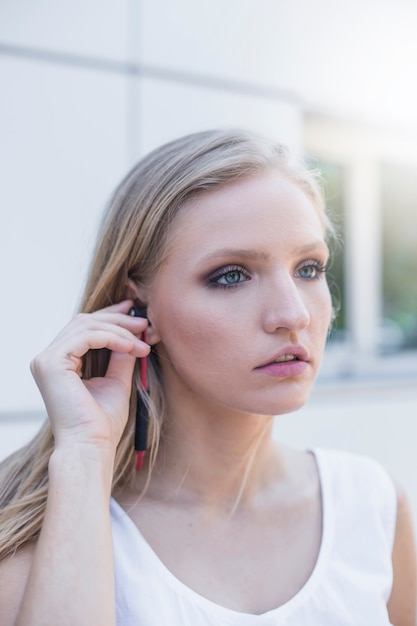 Blonde jeune femme écoutant de la musique sur les écouteurs