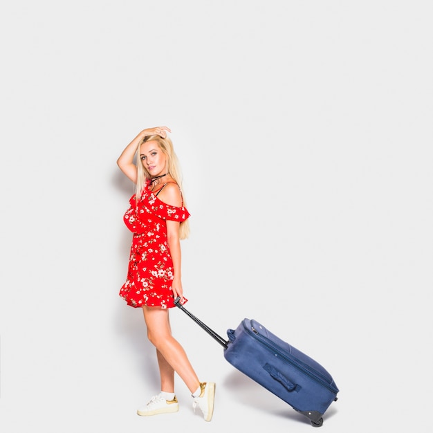 Blonde touriste posant avec valise