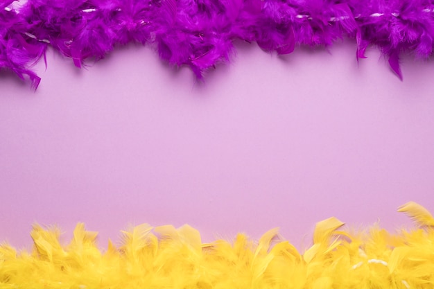 Photo gratuite boas de plumes colorées sur fond violet avec espace copie