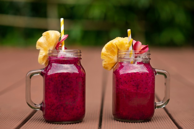 Bocaux en verre à l'extérieur avec du jus de fruit du dragon